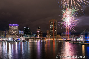 Fine art photograph of New Year's fireworks in sky and reflected in water at night in Inner Harbor, Baltimore City, Maryland.