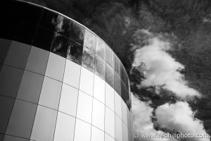 Black and white fine art photo of IMAX theater at the Maryland Science Center, Baltimore, Maryland. Sky with puffy clouds.