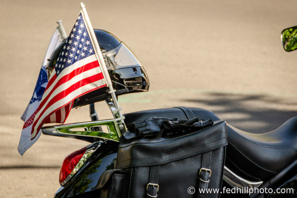 Fine art photograph of a motorcycle seat, motorcycle helmet, and United States flag attached to the seat.