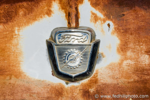 Fine art photo of rusted and decayed antique vintage Ford pickup truck hood ornament.