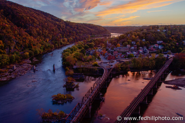 Fine art photo of autumn sunset over Harpers Ferry, railroad bridges, and confluence of Shenandoah and Potomac rivers in WV.