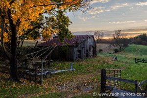 Fine art autumn nature and agriculture photo of sunrise, farmland, barn, trailer.