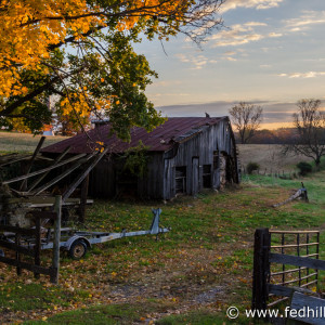 Fine art autumn nature and agriculture photo of sunrise, farmland, barn, trailer.