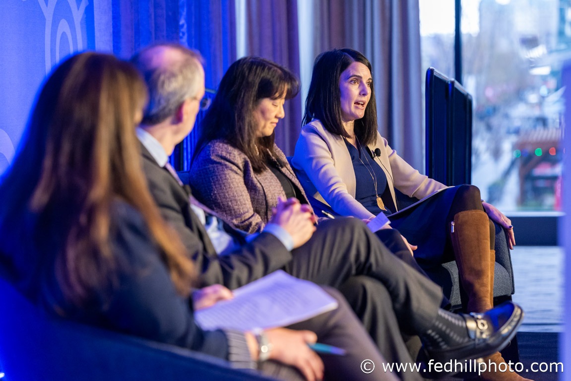 Corporate event photo of a discussion panel on stage.