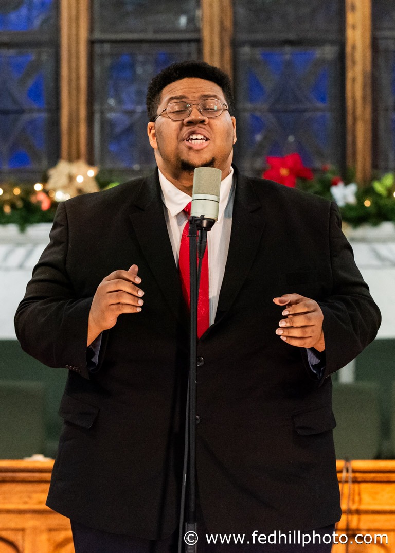 Concert photo of a choir member singing.