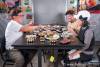 Tourism/lifestyle/restaurant photo of people laughing and eating at a table set with food and beverages.